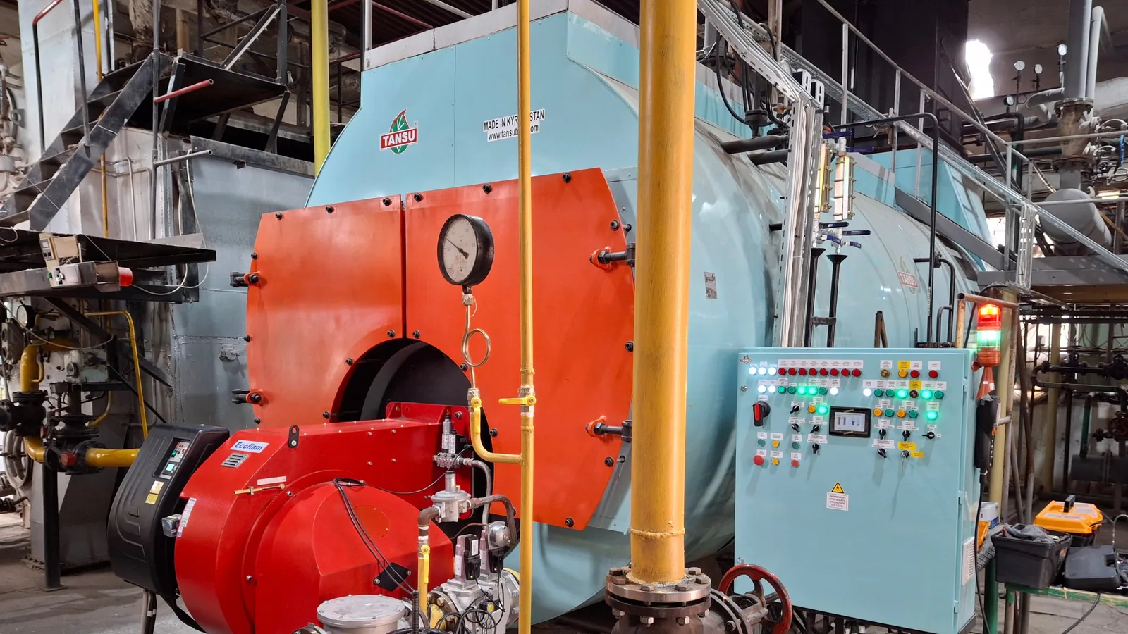 TANSU boiler with an Ecoflam gas burner and a control cabinet in a boiler house